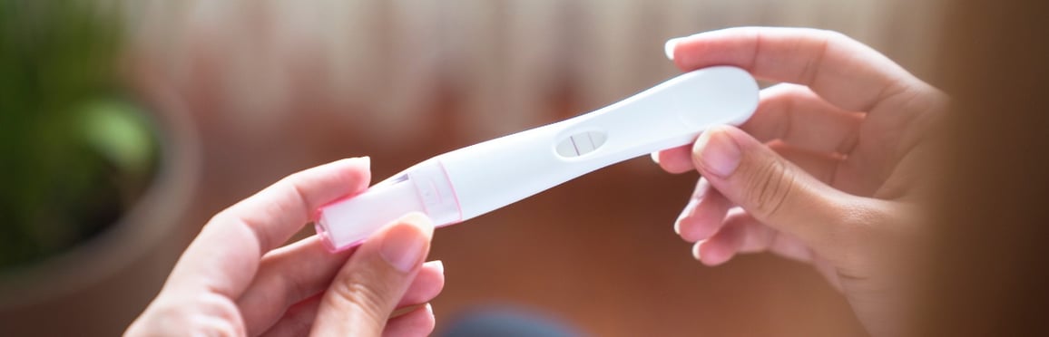 Two Hands Holding Pregnancy Test